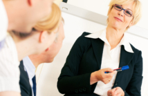 Business team receiving a presentation held by a co-worker standing in front of a flipchart